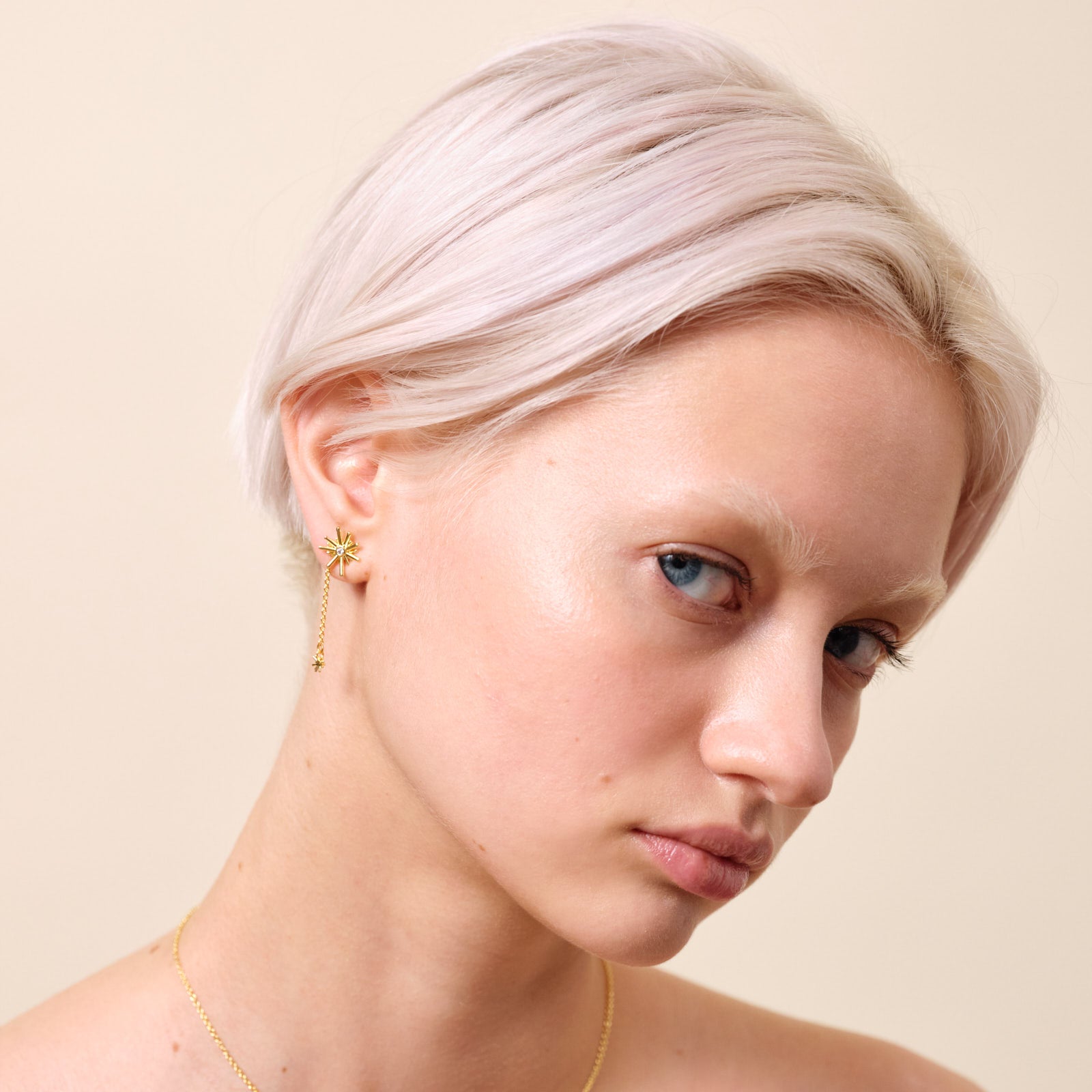 Gold stars and white stone dangling post earrings