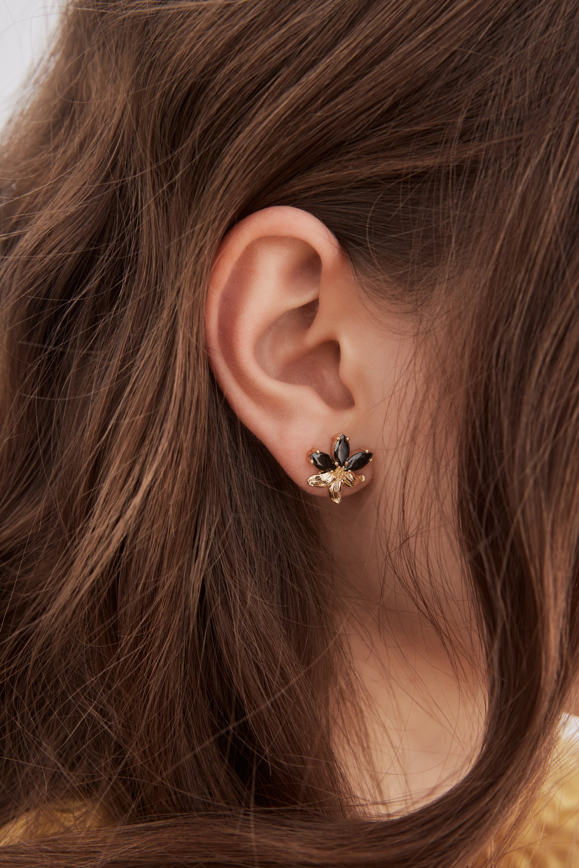Gold lily and black stone post earrings