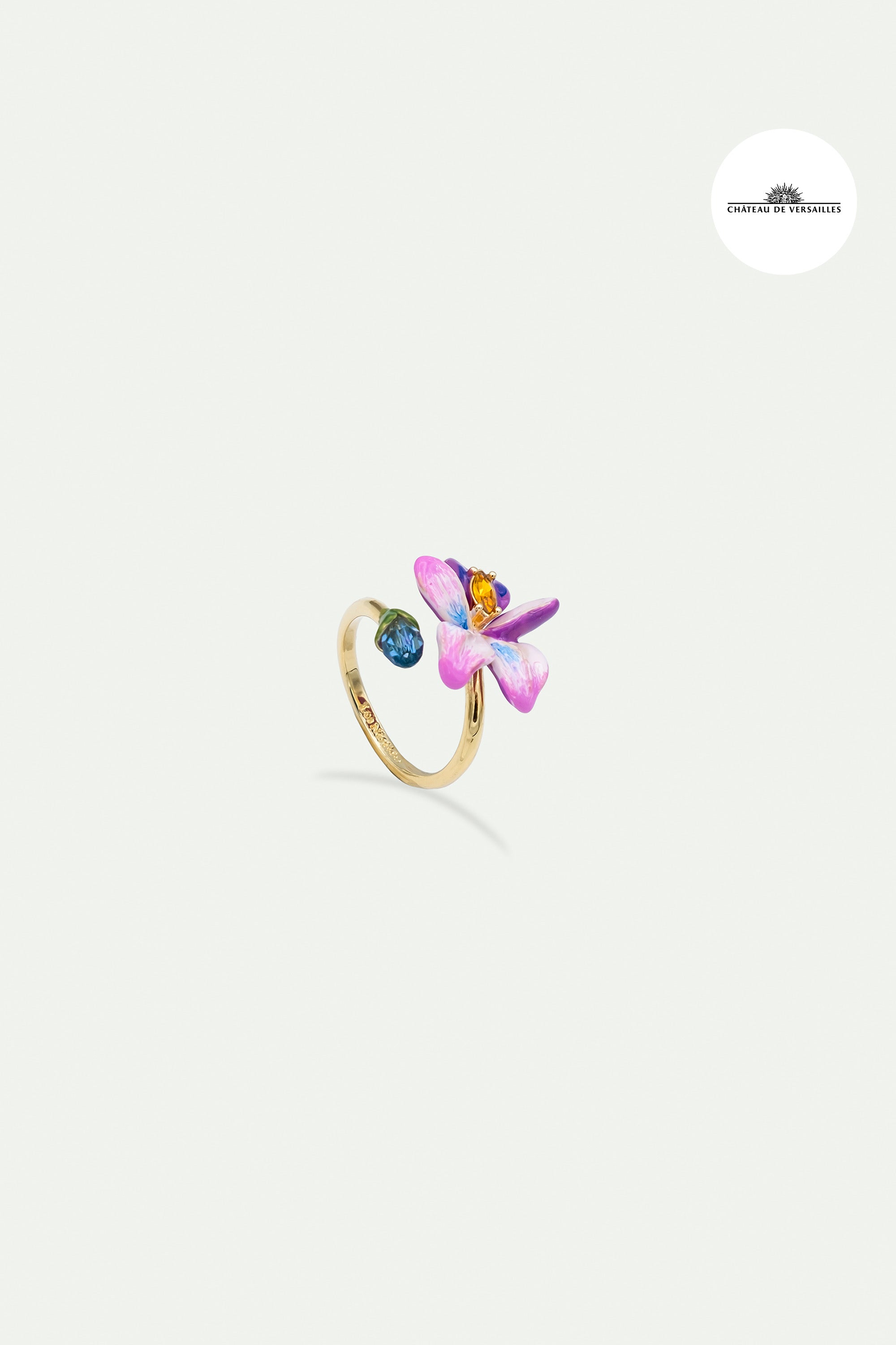 Adjustable ring with violet flower and blue cut stone