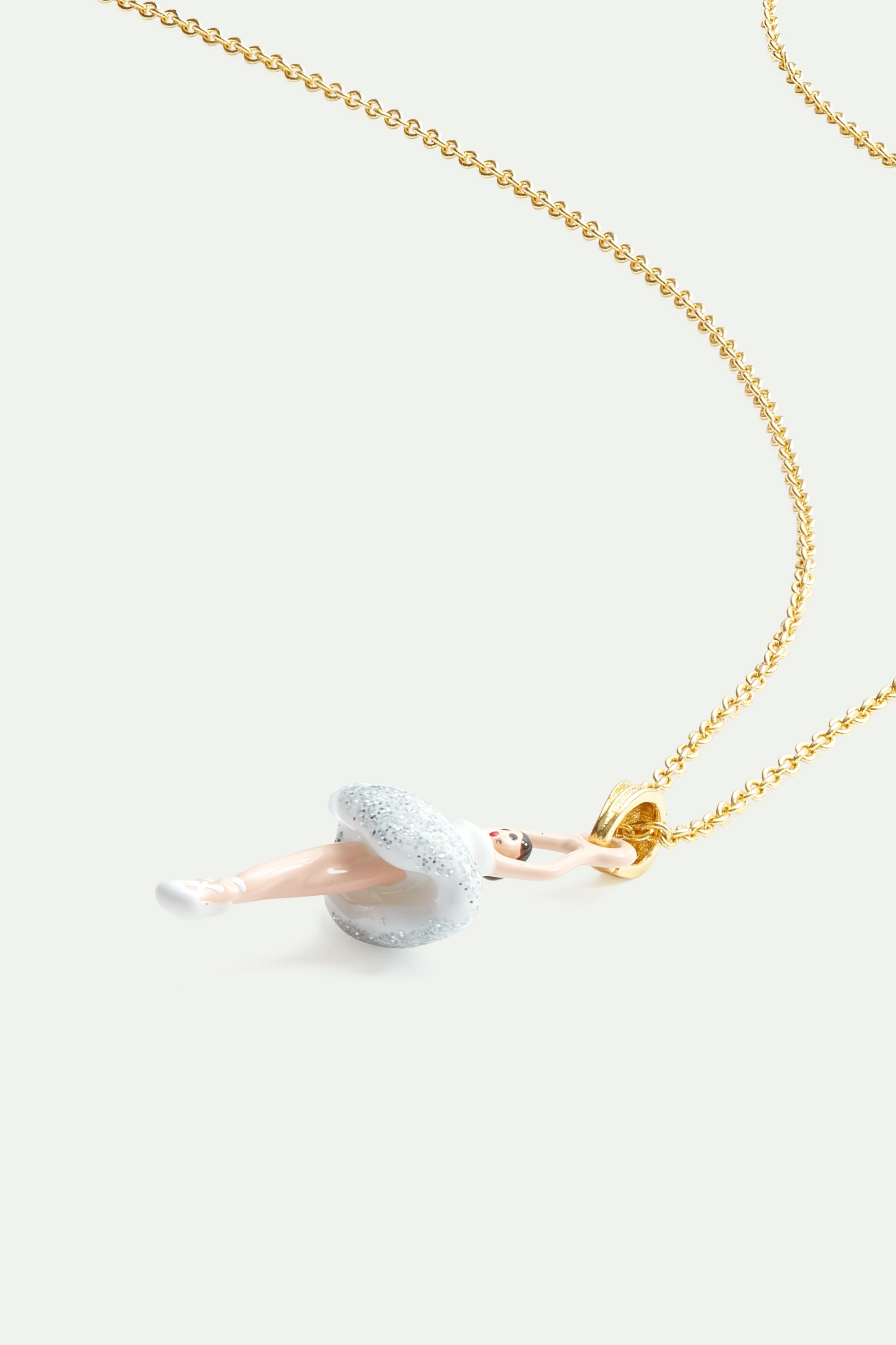 Ballerina wearing a white tutu with silver glitter pendant necklace