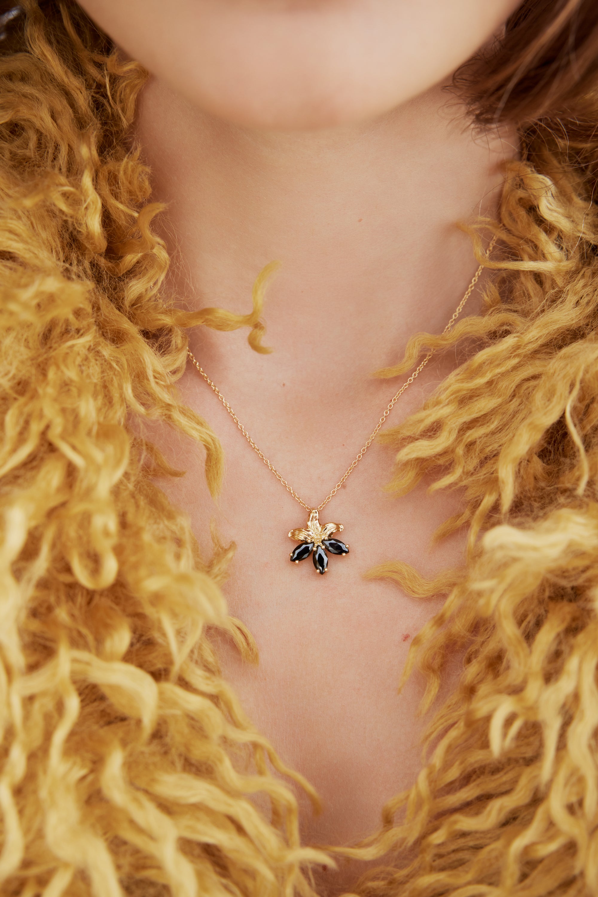 Gold lily and black stone pendant necklace