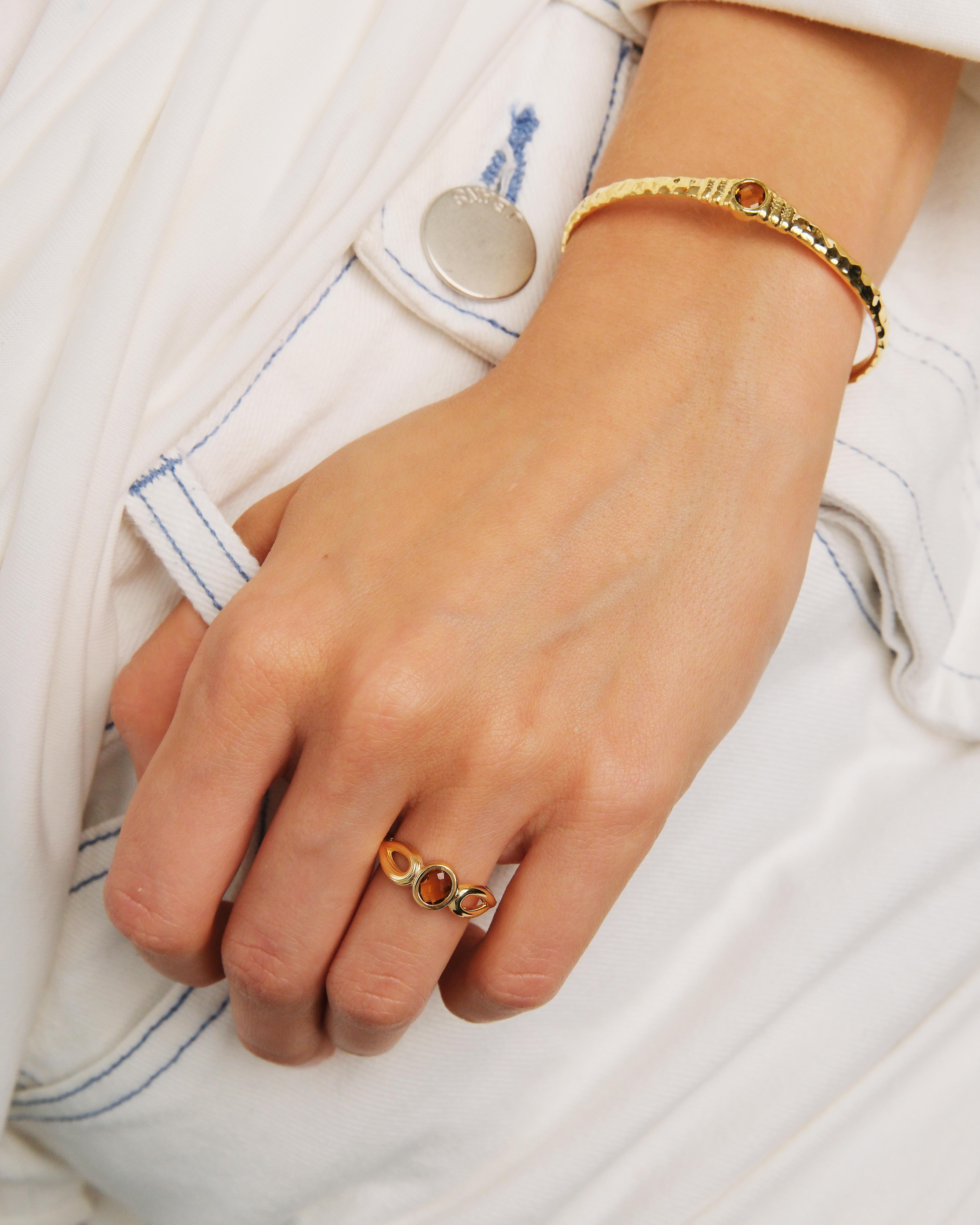 Thin gold ring, striated texture and faceted glass